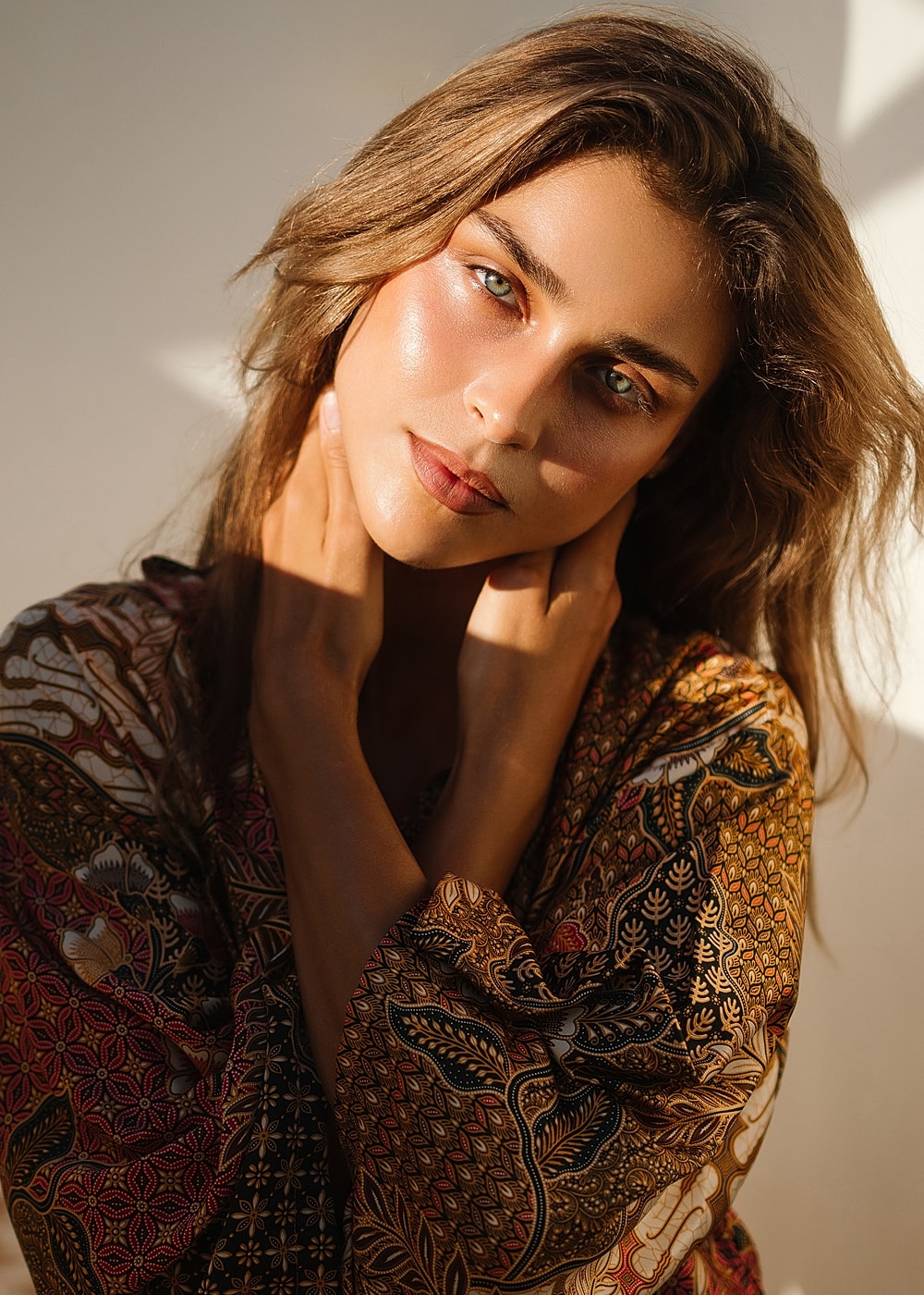 Woman with flowing hair in patterned garment.