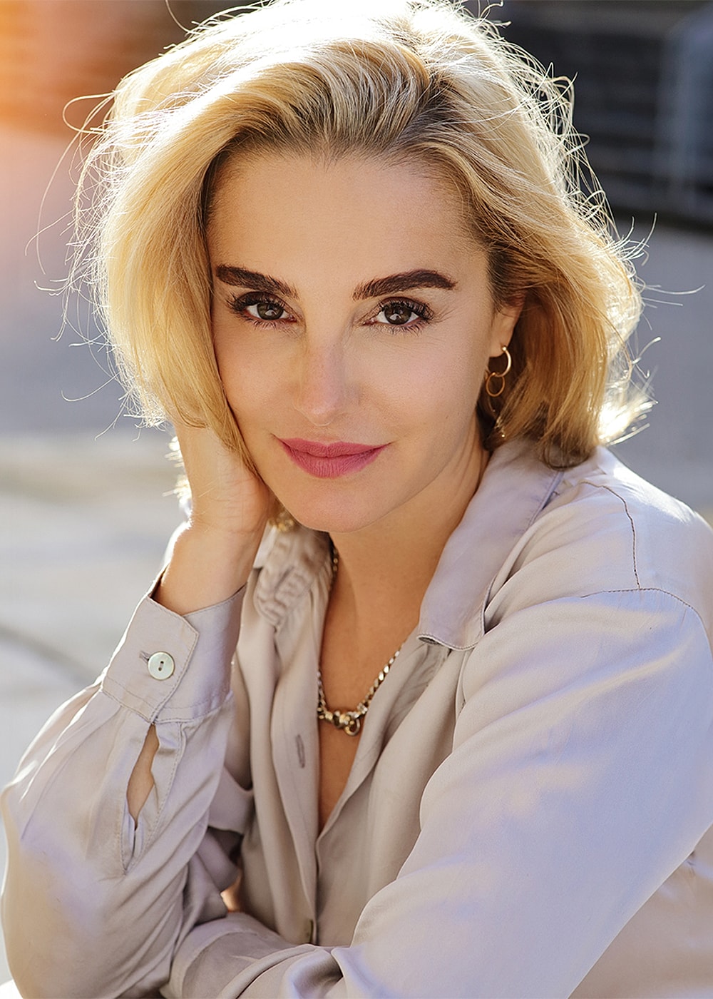 Portrait of a woman with blonde hair and jewelry.